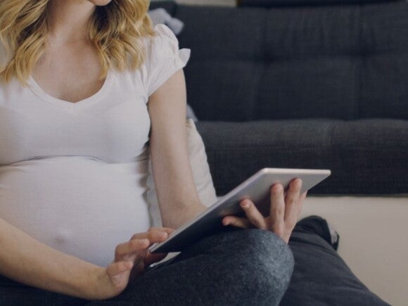 Pregnant woman looking at a tablet