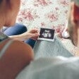 couple looking at picture of baby scan