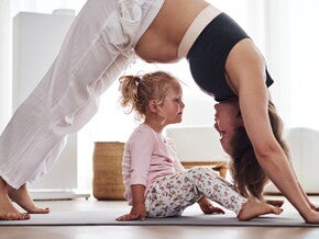 Pregnant woman doing yoga with child under arch