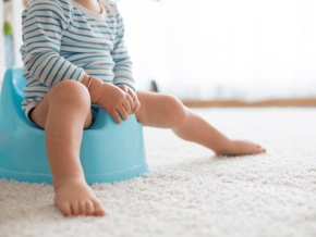 toddler in striped bodysuit sitting on blue potty