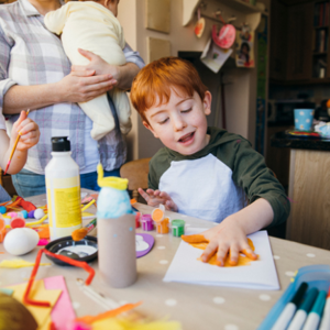 Toddler boy painting with his hands