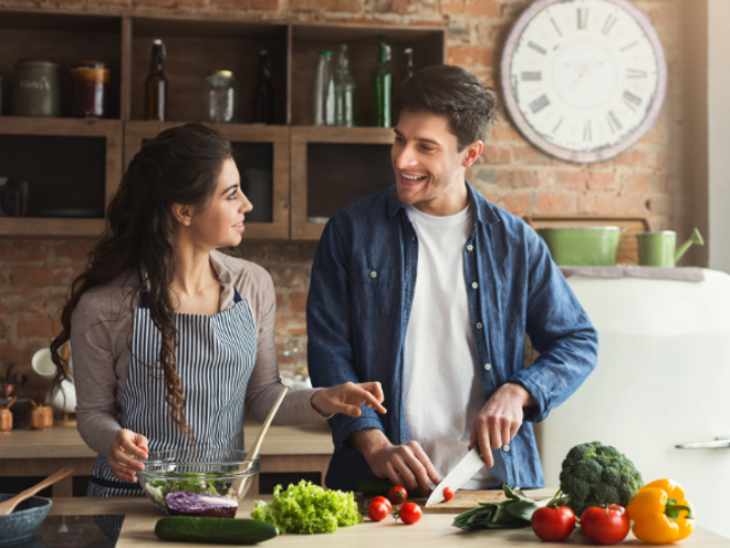woman and man in the kitchen cutting up healthy food