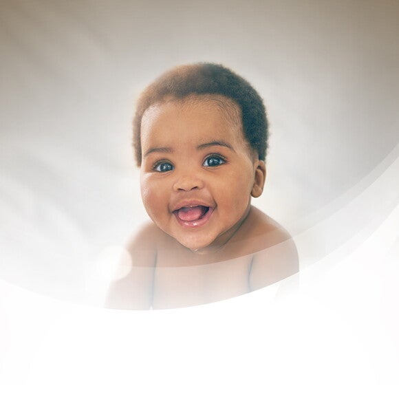 Smiling toddler with a dark grey background